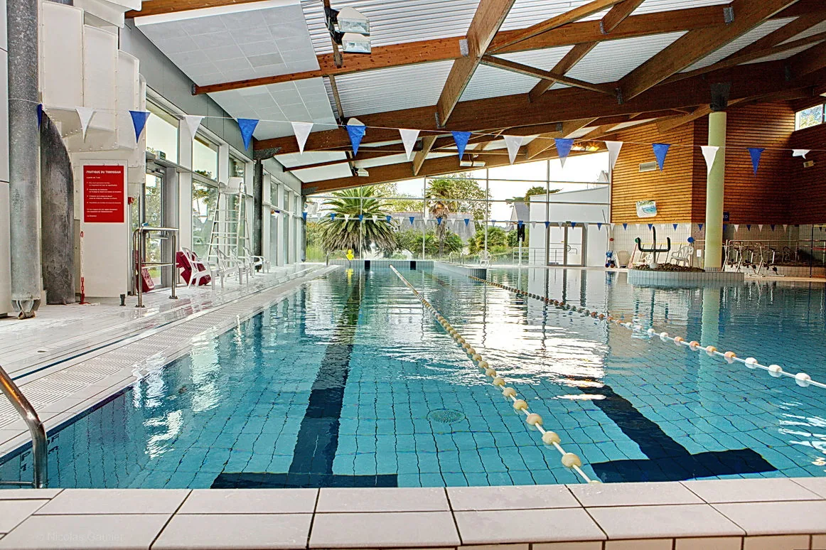 Le bassin intérieur de la piscine Nautil’Ys à Crozon, avec lignes de nage et charpente en bois.
